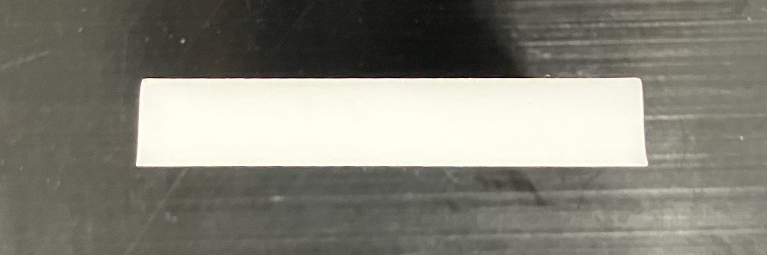 Side view of a laser-cut acrylic part, showing the taper